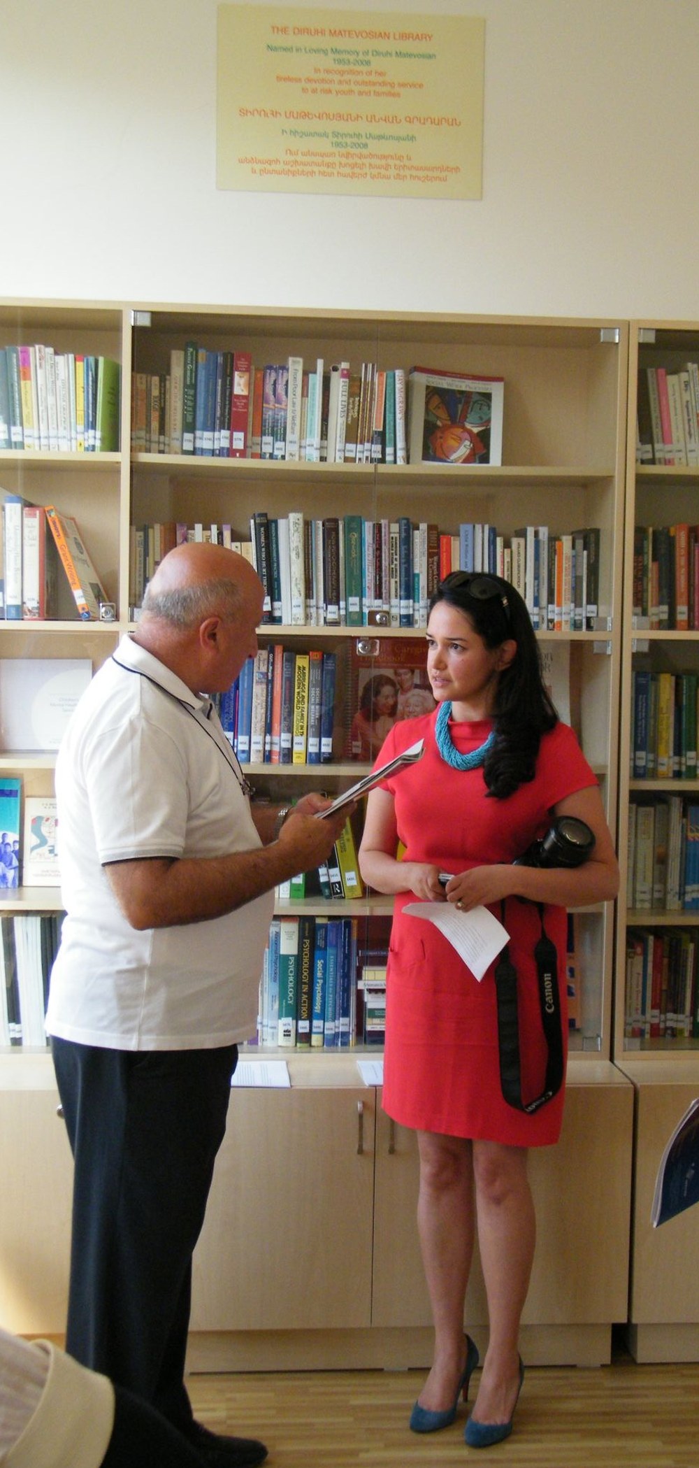 Guests at The Diruhi Matevosian Library in Yerevan, beneath the library's dedication plaque
